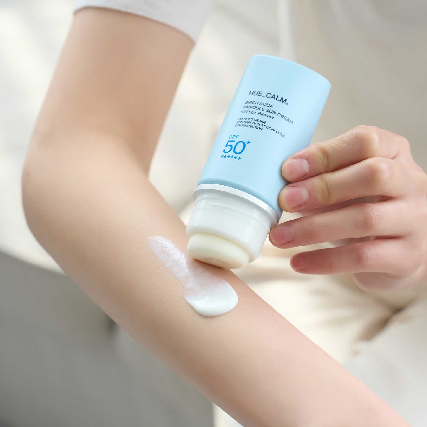 Applying Huecalm Birch Aqua Sun Cream to arm