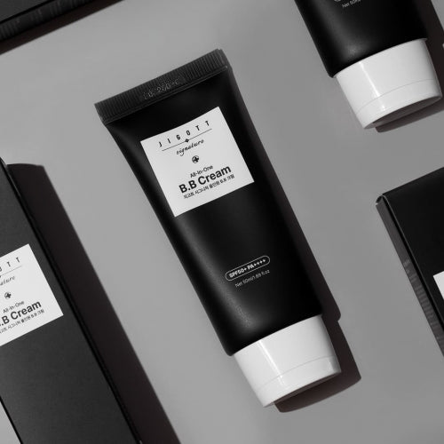 Jigott All-in-One BB Cream black tube flatlay with boxes on gray background