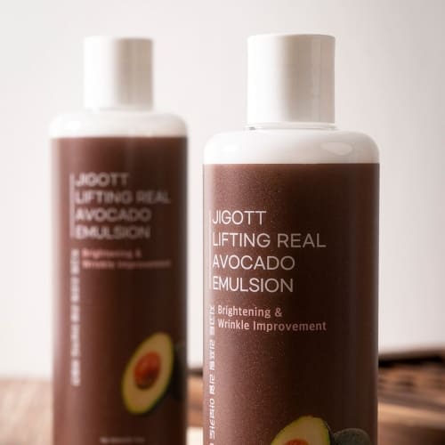 Close-up of two JIGOTT emulsion bottles with soft lighting on wooden table