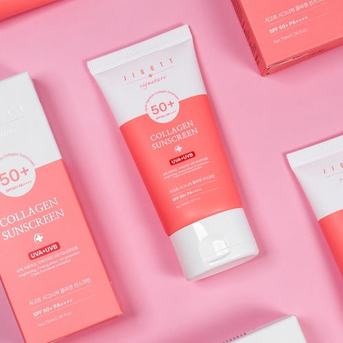 Jigott Collagen Sunscreen tube and box flatlay with multiple products on pink