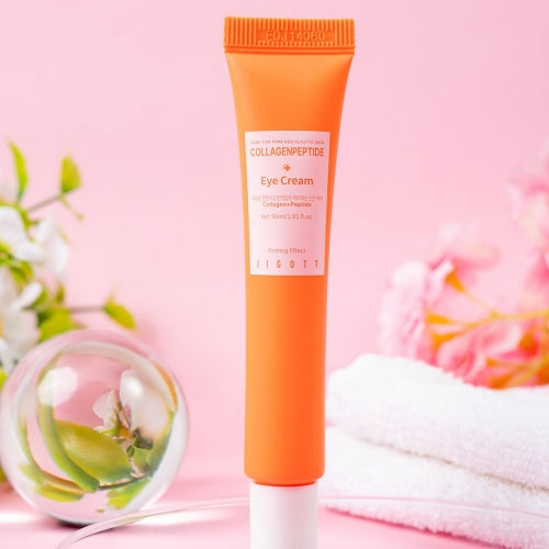 Front view of Jigott Collagen Peptide Eye Cream tube surrounded by soft flowers and towels