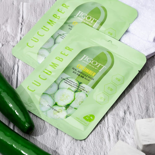 Two sheet masks styled with cucumbers, towel, and wood for natural theme