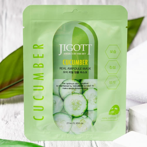 Single cucumber ampoule mask standing with spa props and wood backdrop