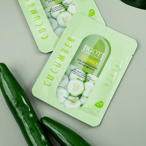 Flatlay image of JIGOTT Cucumber Mask with real cucumbers and green tone