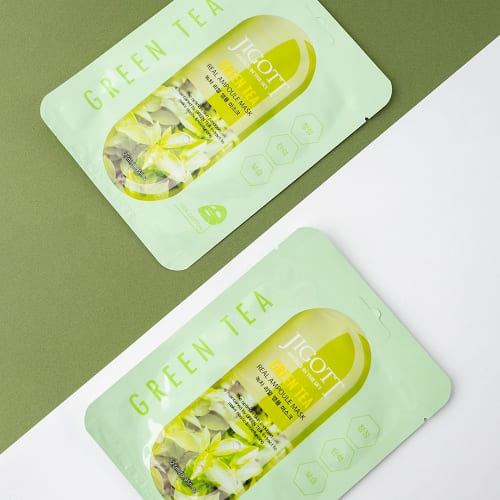 Two Jigott green tea masks laid flat on clean green and white background