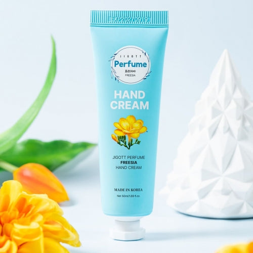 Freesia hand cream tube displayed with fresh yellow freesia and sky-blue background