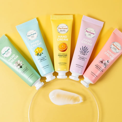 Top-down view of hand cream texture next to all five scented tubes on yellow background