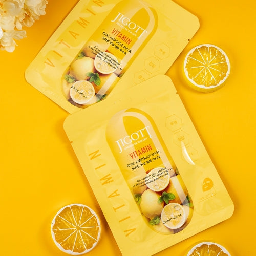 Two vitamin ampoule masks laid flat with citrus and floral elements