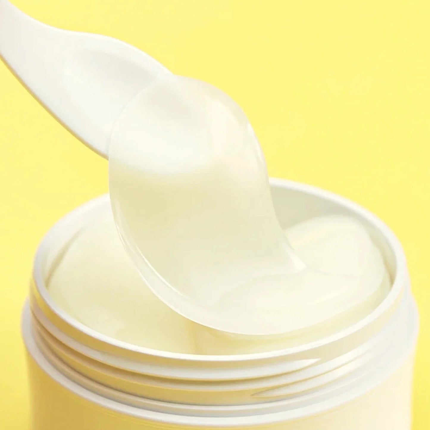 Close-up of translucent hydrogel Vita Collagen Eye Patch lifted with spatula from jar