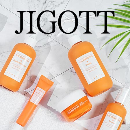 Jigott Collections Collagen peptide skincare collection flatlay featuring foam cleanser, toner, cream, mist, and eye cream on marble with towel and palm leaf