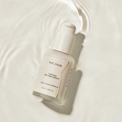 Flat lay image of Huecalm Firming Serum on white surface with glow