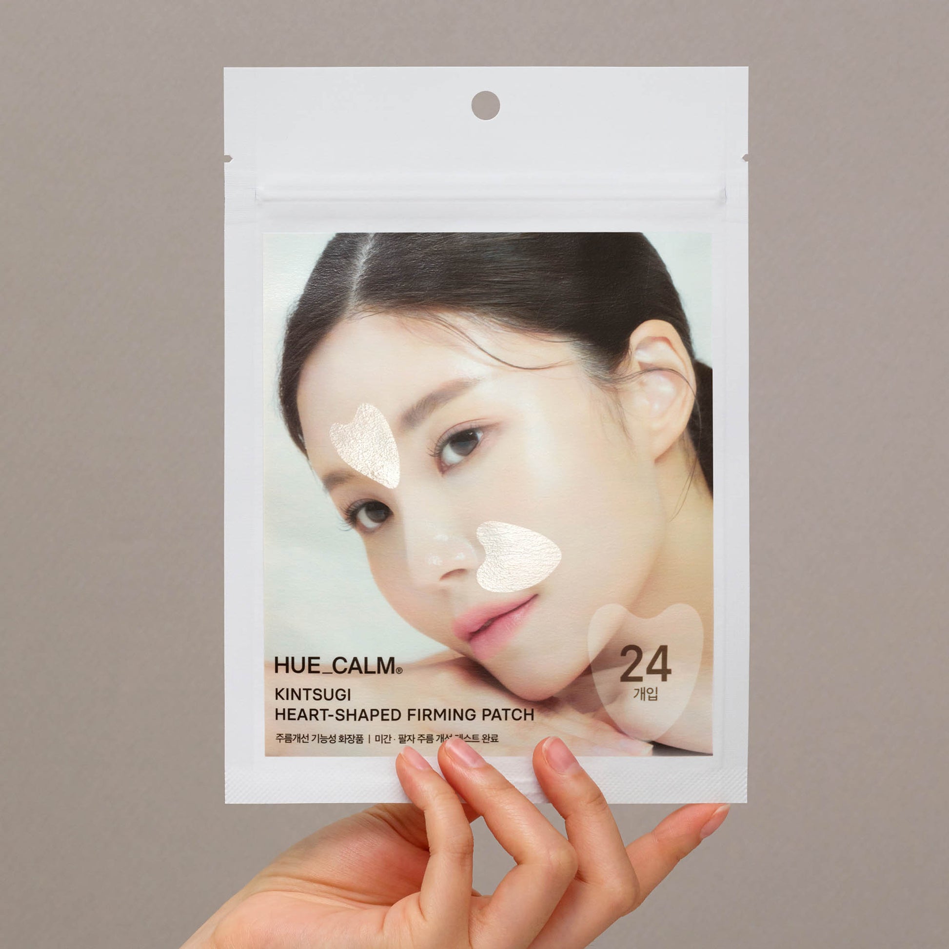 Hand holding Hue Calm Kintsugi Heart-Shaped Anti-Wrinkle Patch pouch – Korean vegan skincare packaging with heart-shaped lifting patches for face
