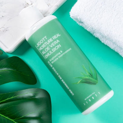 Flatlay of aloe emulsion bottle on green background with marble tray and towel for spa setting
