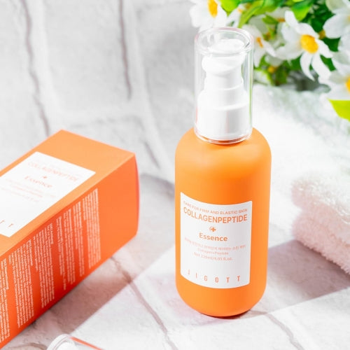 Lifestyle scene with Jigott Collagen Peptide Essence, retail box, and spa towel