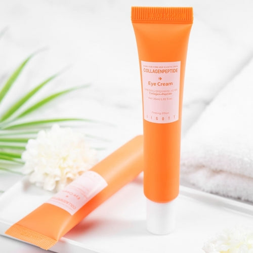 Soft-lit shot of Jigott Eye Cream with another tube in the background and white floral accent