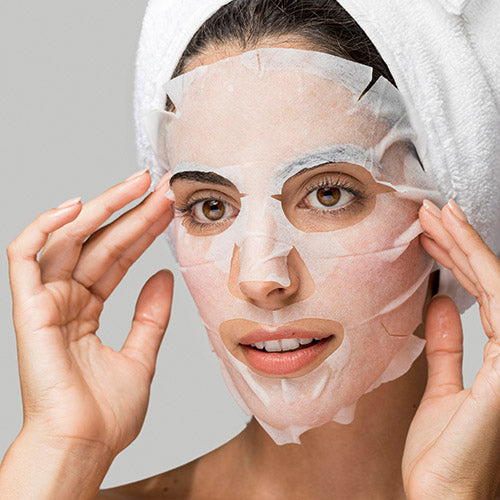 Model applying sheet mask to face, showing fit and adherence of green tea ampoule mask